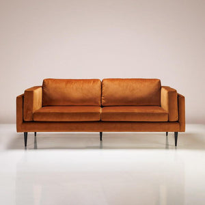 An Astro Sofa upholstered in amber-coloured fabric with wooden accents