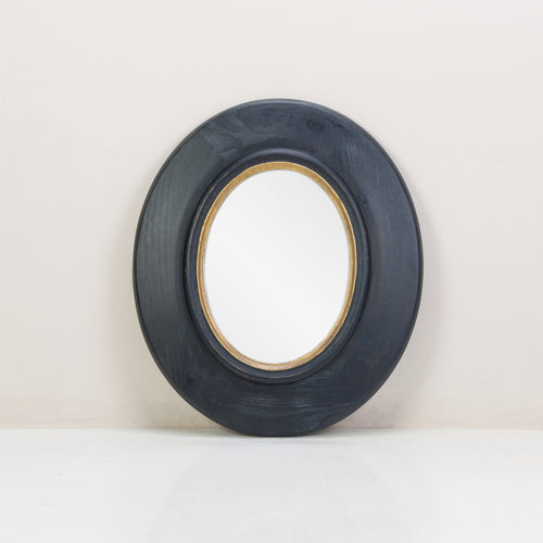 A black and gold oval mirror