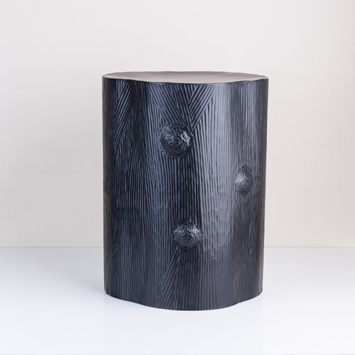 A black stump stool made of powder coated iron