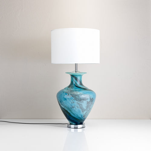 Glass table lamp with a fabric shade, available in white, blue, or grey colour