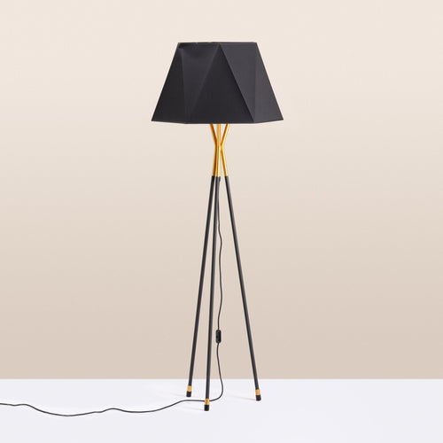 A black and gold tripod floor lamp