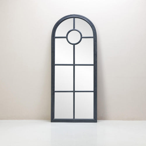 An arched framed mirror with a black metal frame